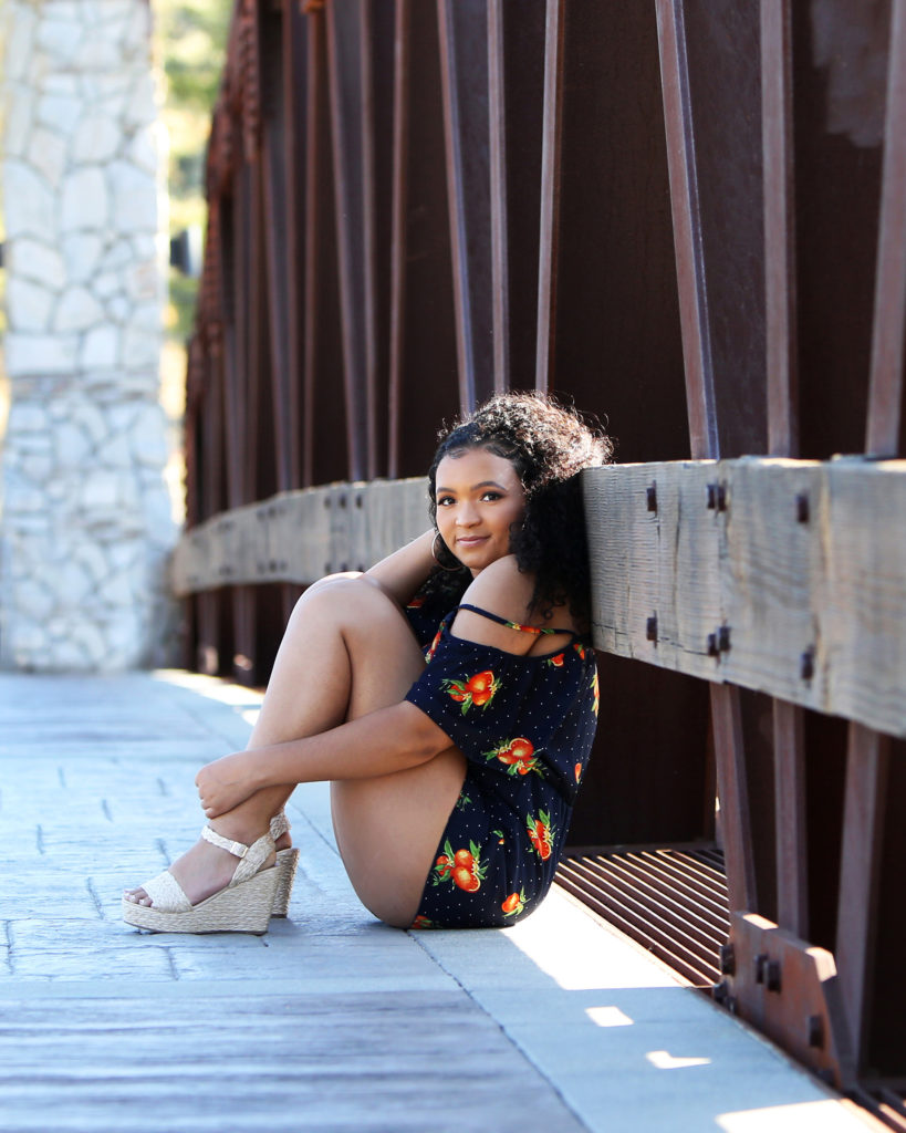 teen girl sitting on bridge
